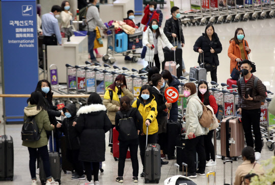 국내에서 신종 코로나바이러스 감염증 네번째 확진환자가 발생한 27일 오후 인천국제공항 1터미널에서 마스크를 쓴 외국인 관광객들이 입국하고 있다.    연합뉴스